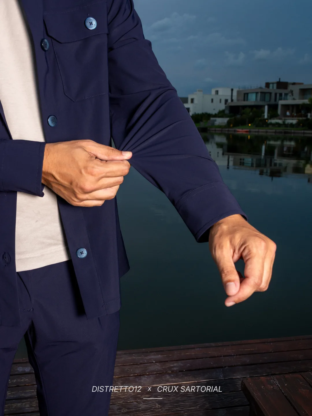 Manga de un saco azul de Distretto12 × CRUX Sartorial estirada para mostrar la elasticidad del tejido